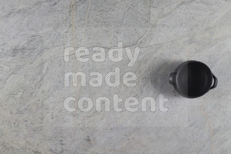A black pottery bowl on grey marble background