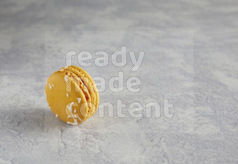 45º Shot of Yellow Piña Colada macaron on white  marble background