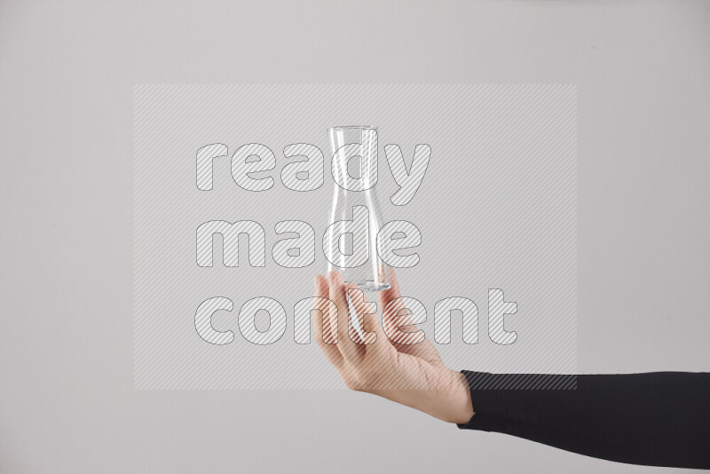 امرأة ترتدي عباءة سوداء تحمل أدوات زجاجية مختلفة في أوضاع متعددة