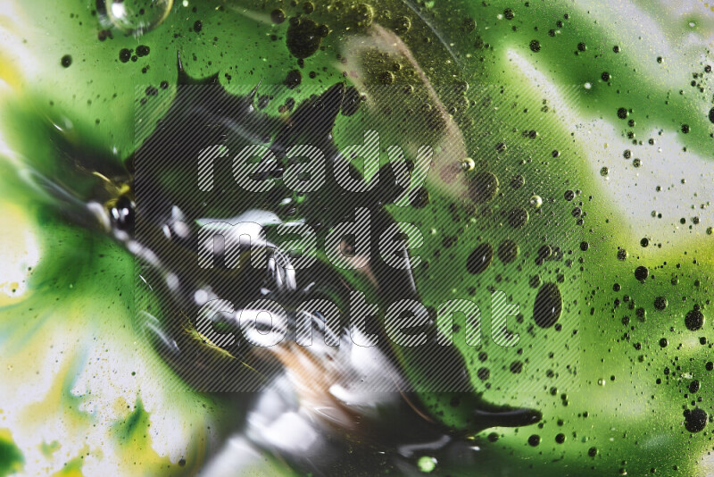 Close-ups of abstract green and yellow watercolor drops on oil Surface on white background