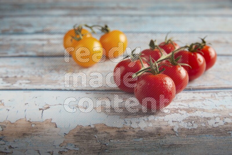 Mixed cherry tomato veins on a textured light blue wooden background 45 degree