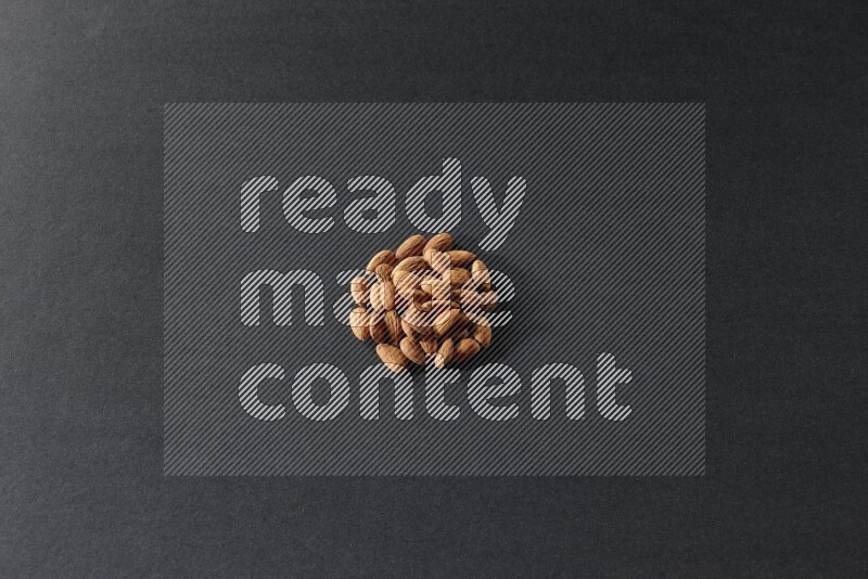 A bunch of peeled almonds on a black background in different angles
