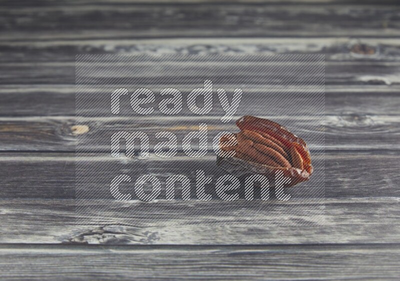 pecan stuffed madjoul date on a wooden grey background