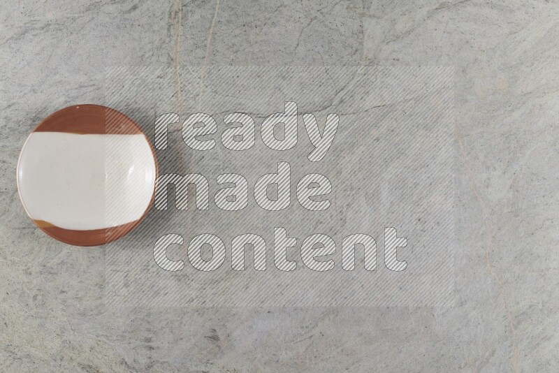 A multicolored pottery plate on grey marble background