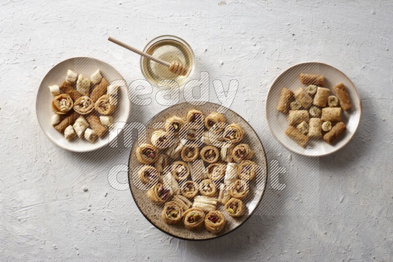 Oriental sweets in pottery plates with honey in a light setup