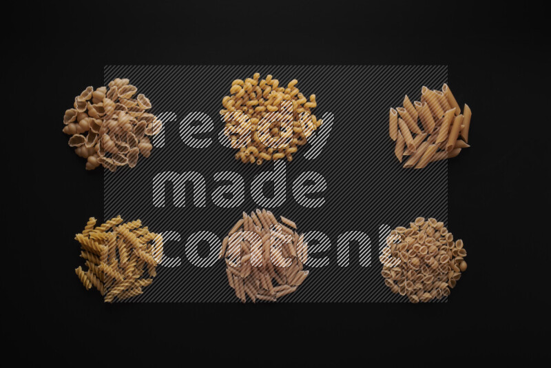 Different pasta types in bunches on black background