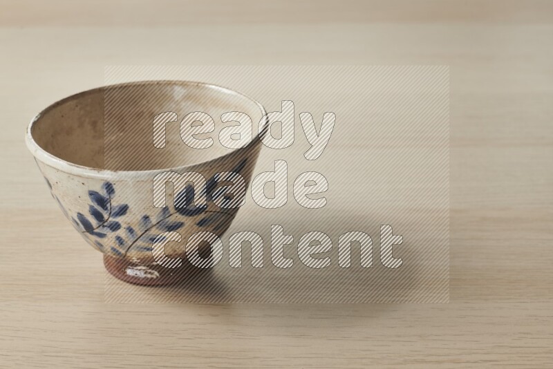 A decorative pottery bowl on light wooden background
