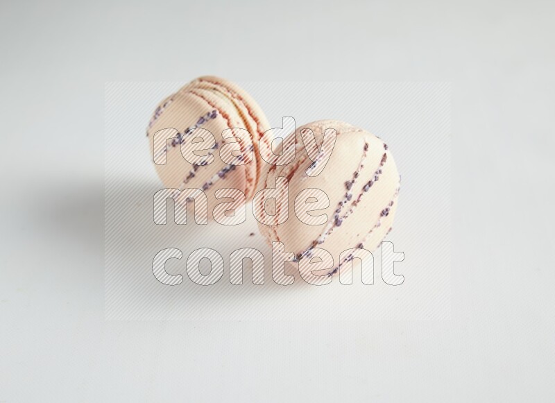 45º Shot of two pink orange blossom macarons on white background