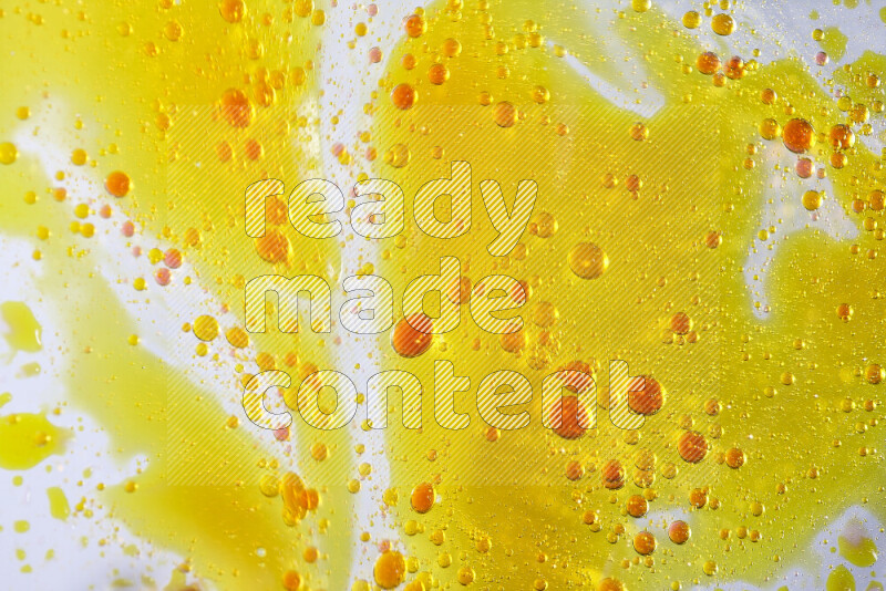 Close-ups of abstract yellow and red watercolor drops on oil Surface on white background