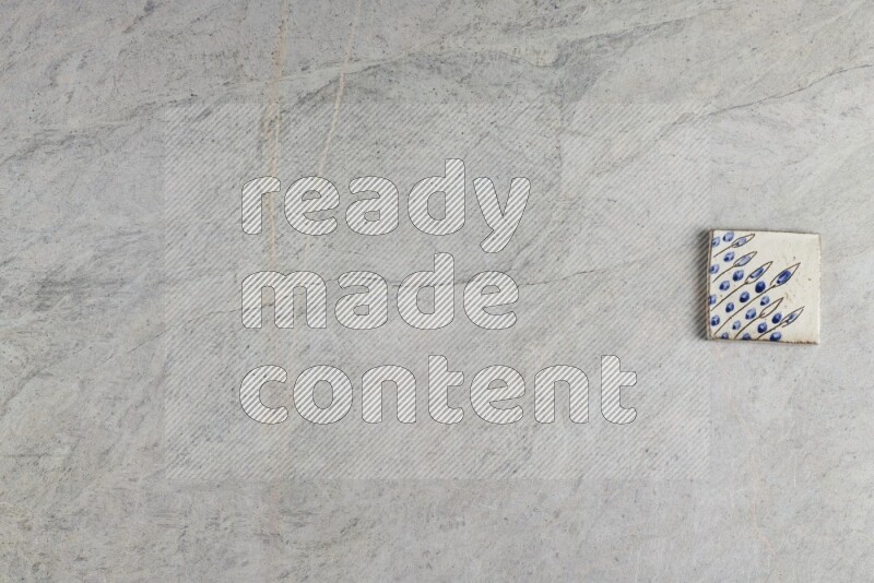 A decorative pottery coaster on grey marble background