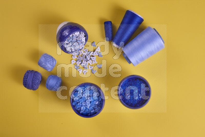 A blue collection of sewing and tailoring tools arranged on a yellow background