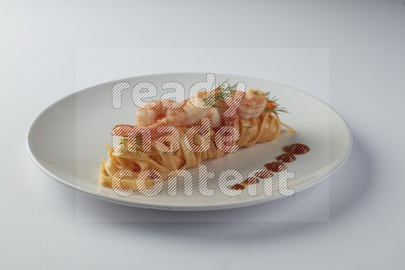 Fettuccini red sauce pasta with shrimp in a white plate on a white background