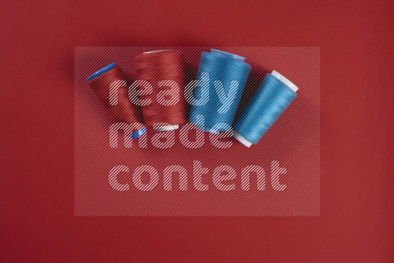A blue and red collection of sewing and tailoring tools arranged on a red background