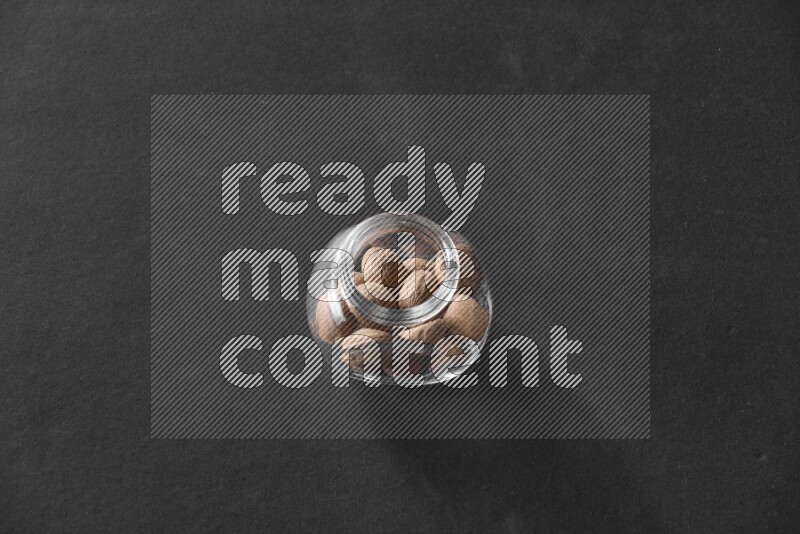 جوزة الطيب في وعاء زجاجي علي خلفية سوداء