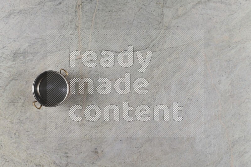 A small copper pot on grey marble background