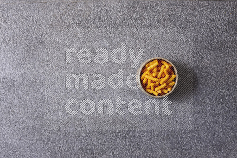 وجبات خفيفة متنوعة في أوعية فخارية على خلفية رمادية