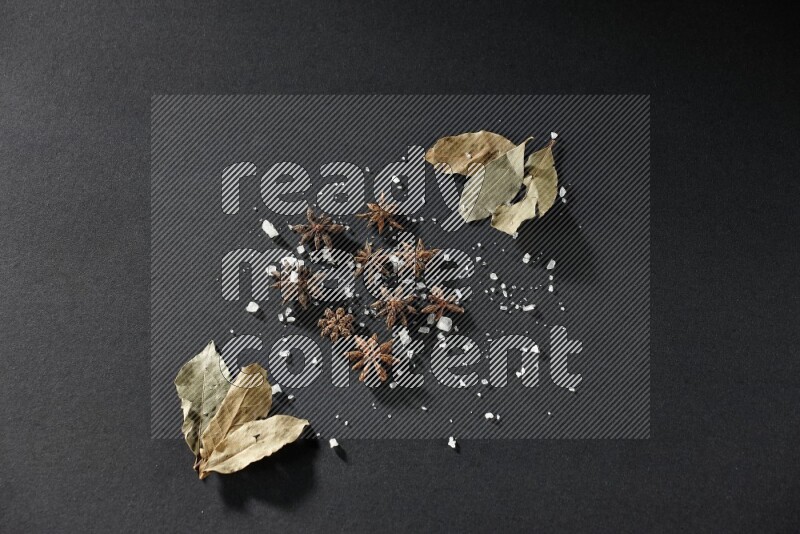 الملح واليانسون النجمي وورق الغار على خلفية سوداء