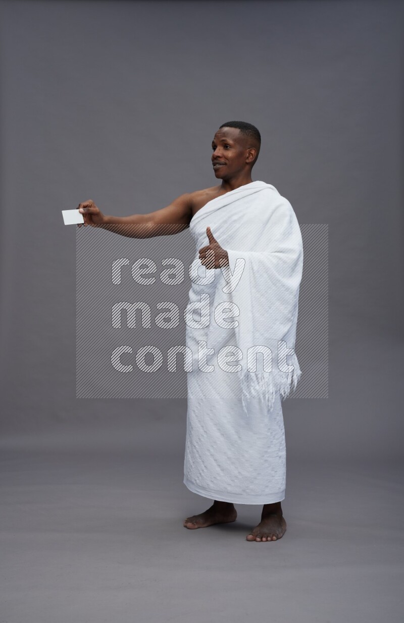 A man wearing Ehram Standing holding ATM card on gray background