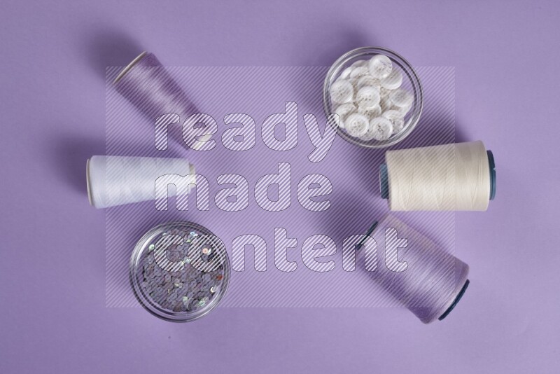 A white and purple collection of sewing and tailoring tools arranged on a purple background