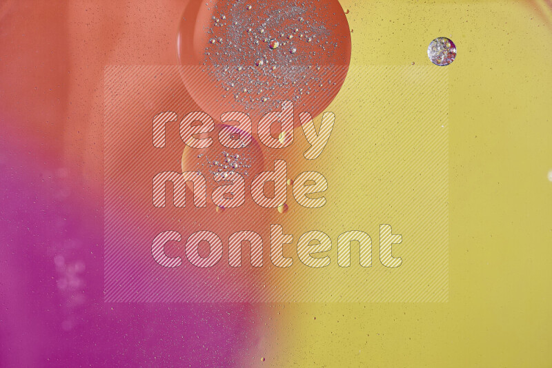 Close-ups of abstract oil bubbles on water surface in shades of yellow, orange and pink
