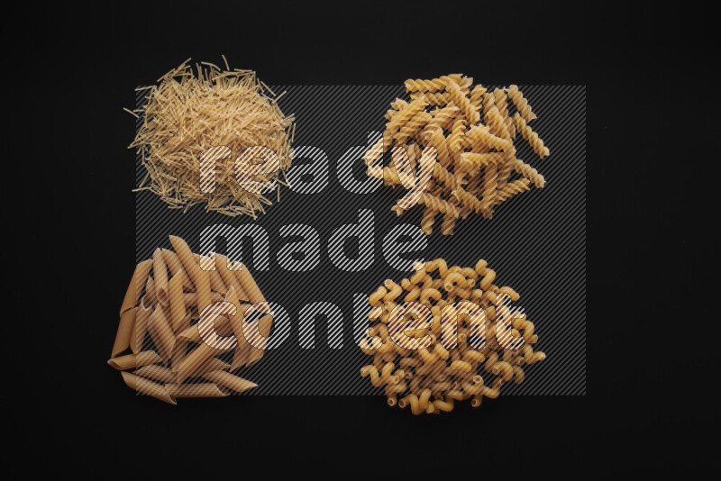Different pasta types in bunches on black background