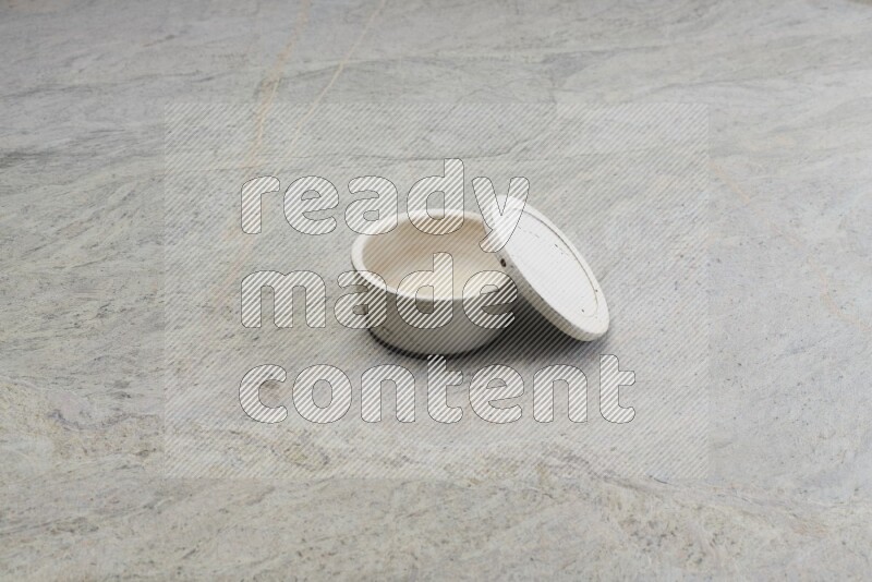A white pottery bowl on grey marble background