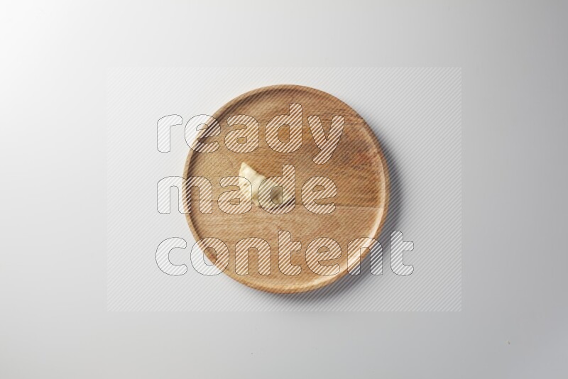 A single Sambosa on a wooden round plate on a white background