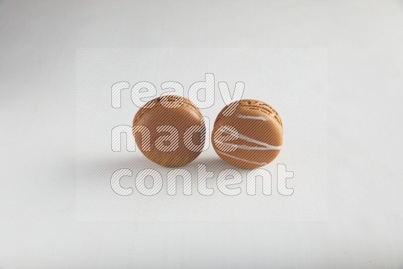 45º Shot of of two assorted Brown Irish Cream, and Brown Coffee macarons  on white background