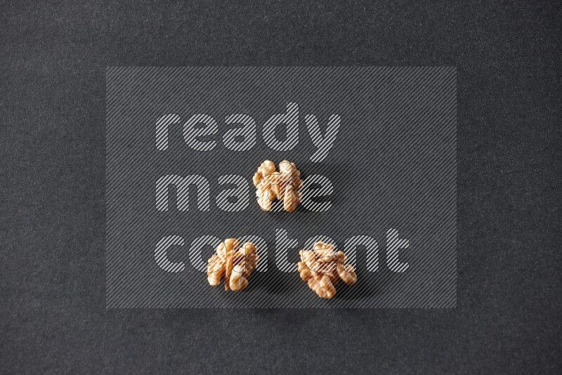 3 walnuts on a black background in different angles