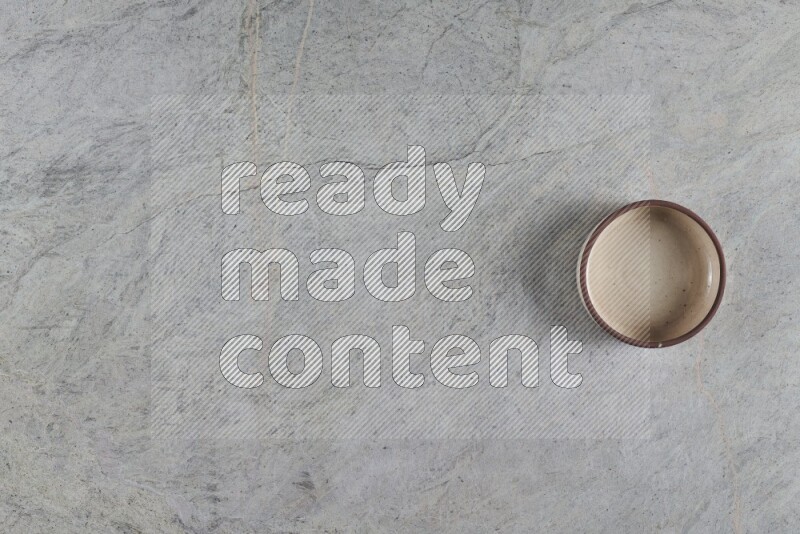 A multicolored pottery oven bowl on grey marble background