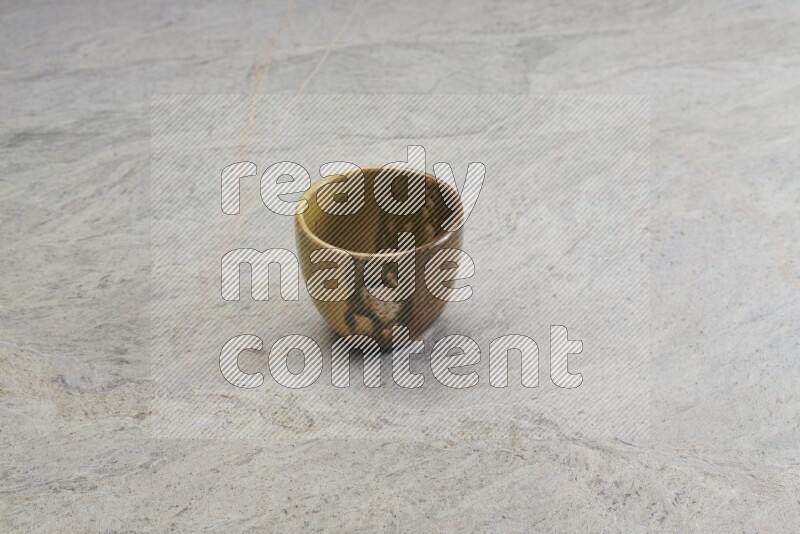 A multicolored pottery bowl on grey marble background