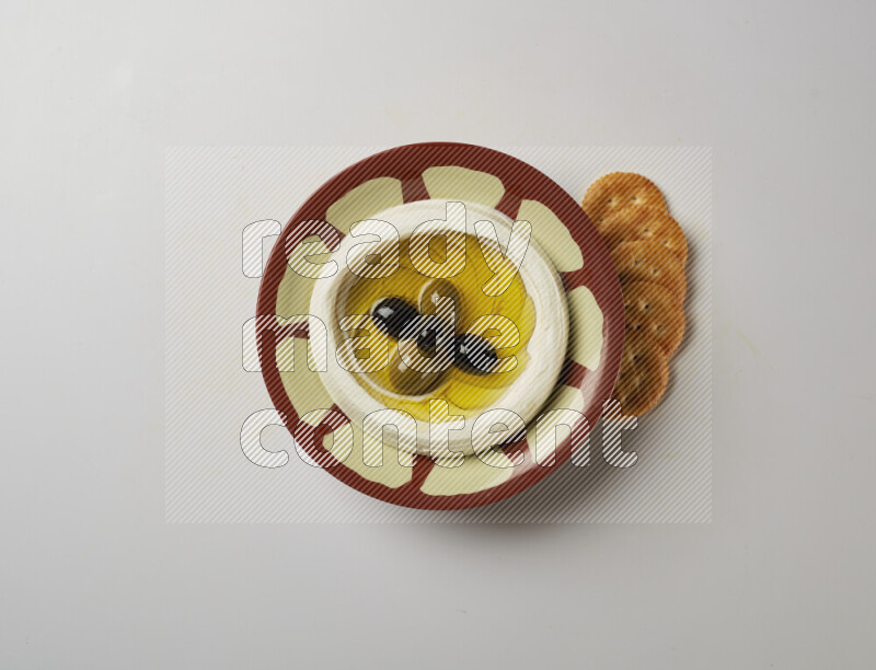 Lebnah garnished with olives in a traditional plate on a white background