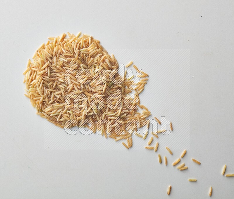 Top-view shot of long grain brown rice on white background