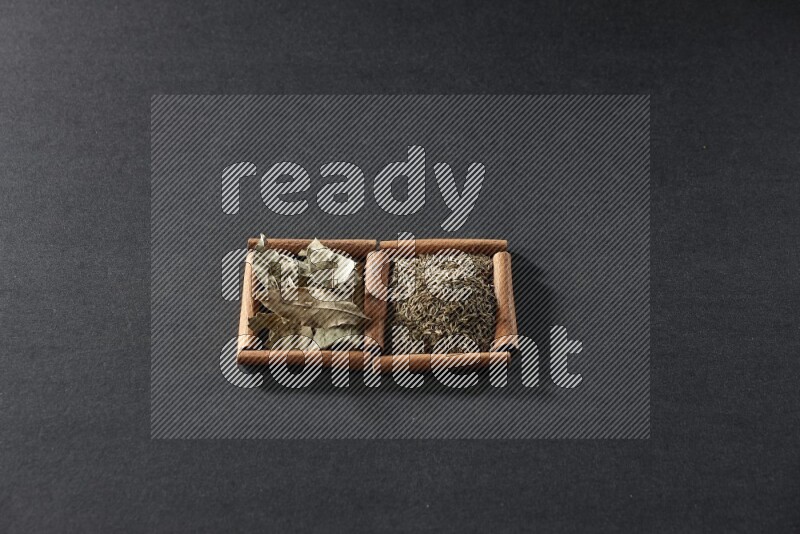 2 squares of cinnamon sticks full of cumin and bay laurel leaves on black flooring