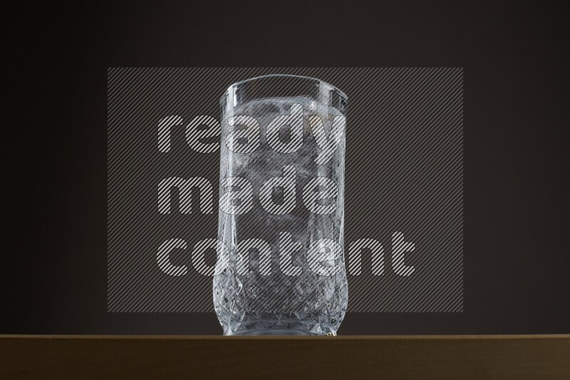 Low angle shot of a glass of water and ice on grey background