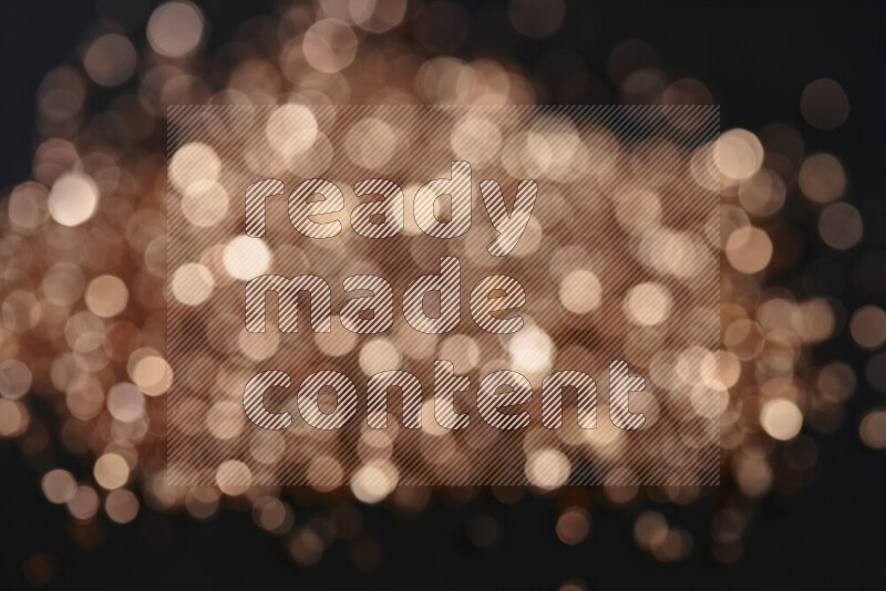 Bronze shimmering fragments of glass scattered on a black background