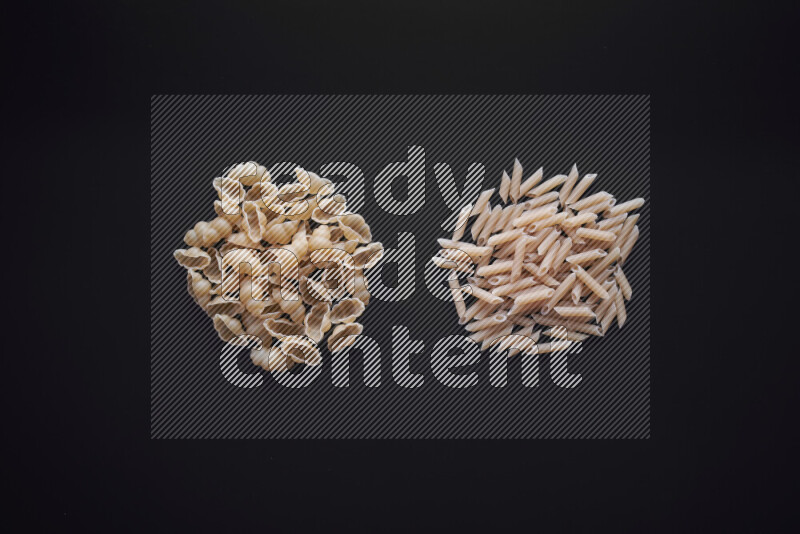 Different pasta types in bunches on black background