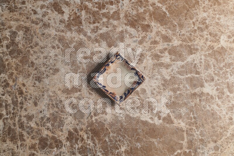 A decorative pottery plate on beige marble background