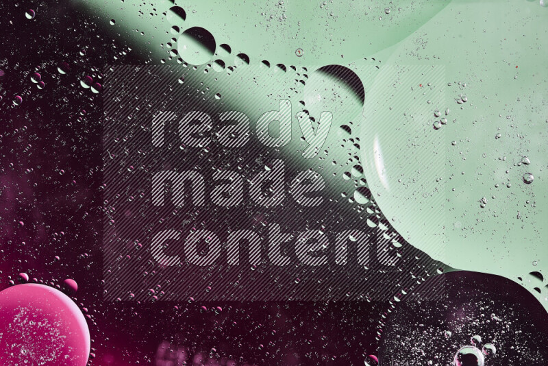 لقطات مقربة لفقاعات من الزيت على سطح الماء باللون الأخضر والوردي