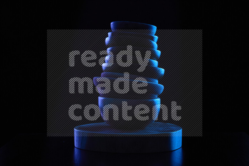 Wooden kitchen essentials with colored rim light against black background