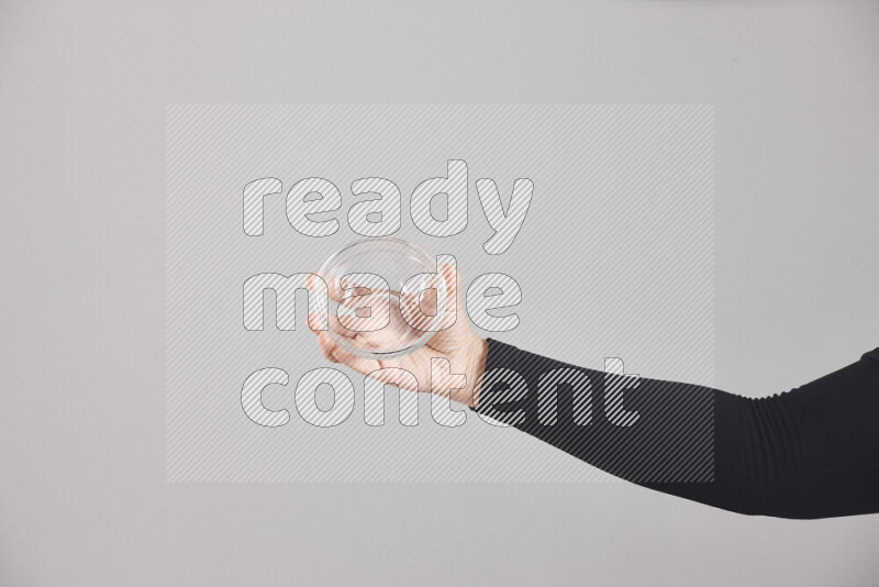 امرأة ترتدي عباءة سوداء تحمل أدوات زجاجية مختلفة في أوضاع متعددة