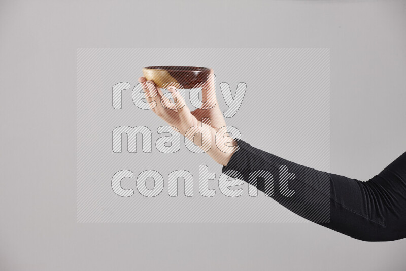 A woman in black abaya holding different wooden essentials in different positions