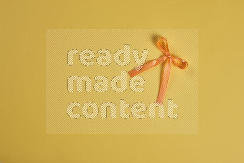 An orange collection of sewing and tailoring tools arranged on a yellow background