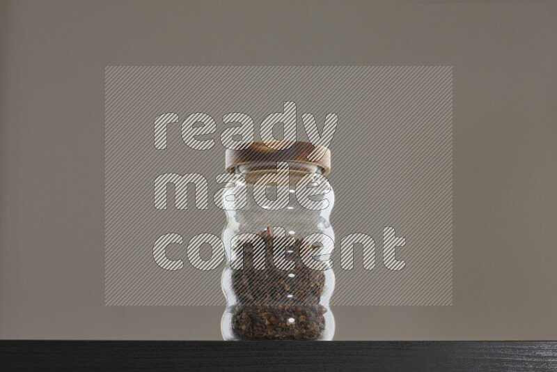 Dried basil in a glass jar on black background