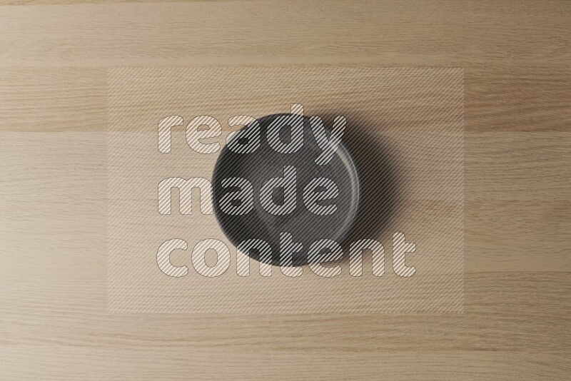 A black pottery oven bowl on light wooden background