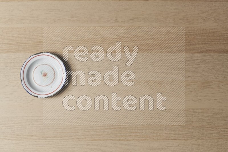 A vintage metal plate on light wooden background