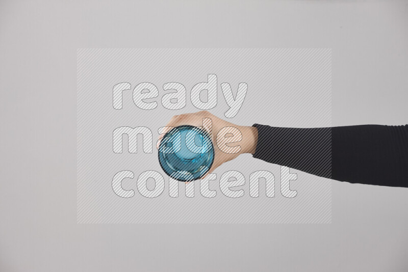 امرأة ترتدي عباءة سوداء تحمل أدوات زجاجية مختلفة في أوضاع متعددة