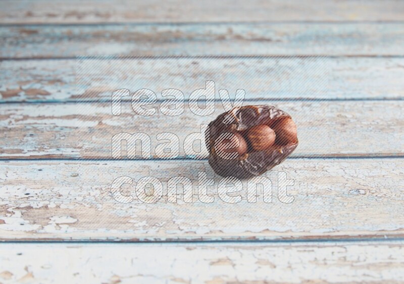 hazelnuts stuffed madjoul date on a light blue wooden background