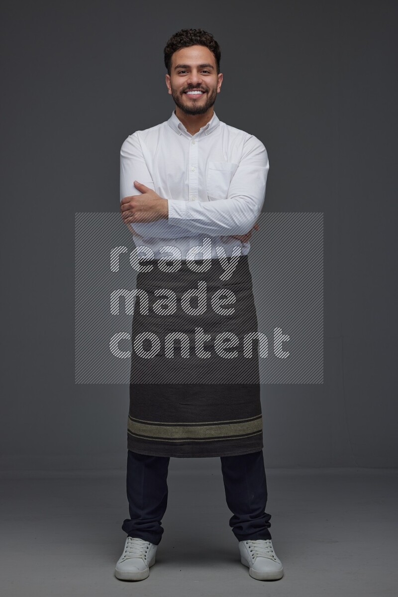 A man wearing smart casual and apron standing and making multi poses eye level on a gray background