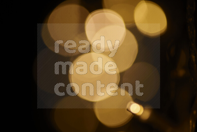 Light bulbs glowing against backdrop of golden bokeh